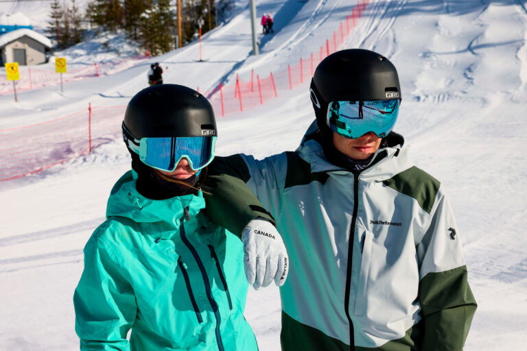 Sisarukset seisoskelemassa aurinkoisessa säässä Taivalvaaran hiihtokeskuksessa